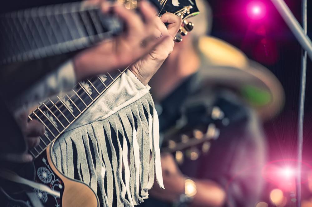 A group of people playing a guitar at a concert.